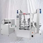 Stroj za označevanje z zamaški za polnjenje steklenic s tekočino z razširjevalnikom